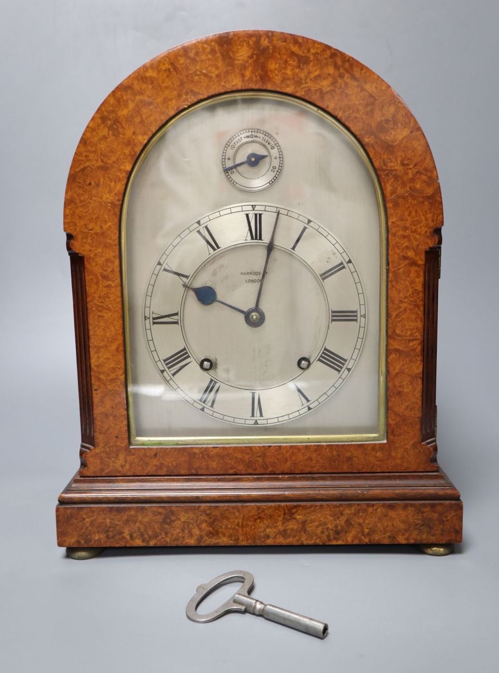 An Edwardian eight day birds eye maple cased mantel clock, with chiming movement, retailed by Harrods, 31cm high
